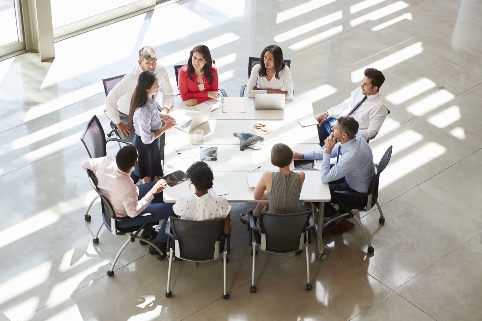 Team meeting around a conference table, viewed from above