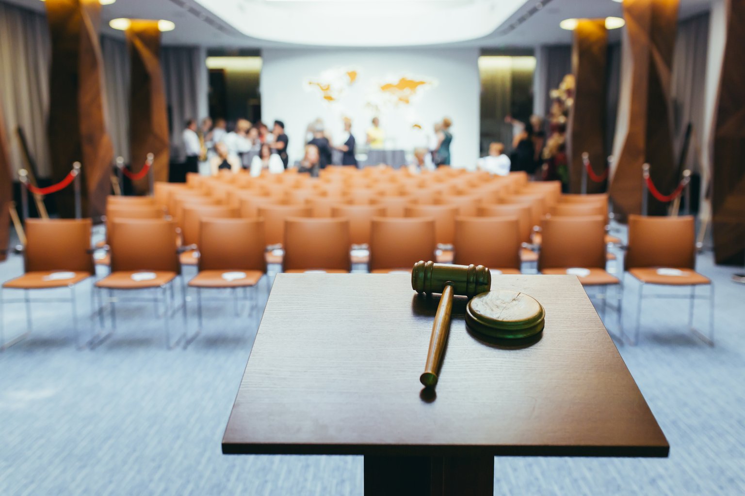 Gavel on a podium in front of rows of courtroom seating